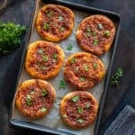 Freshly baked individual portions of Turkish biberli ekmek arranged in a baking pan.