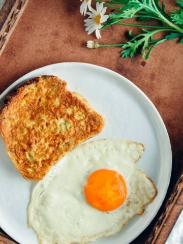 French toast with a fried egg on the side for breakfast and spring flowers accompany.