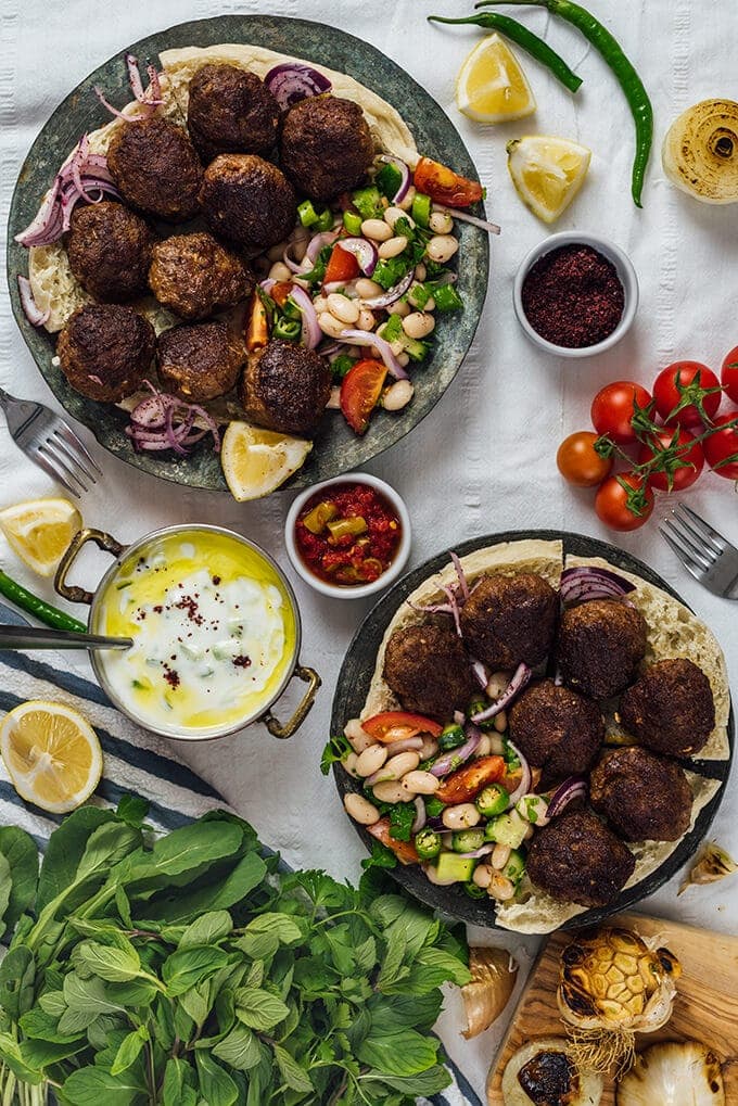 Best Turkish kofte on copper plates with bean salad and cucumber dip