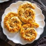 Plate of three golden spiral potato böreks topped with sesame and nigella seeds, labeled “Potato Borek.”