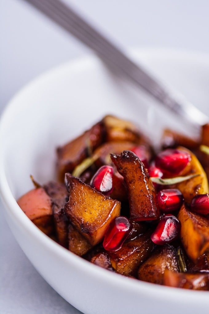 Apple compote with spices is a great recipe to use up apples. Makes a perfect easy apple dessert or breakfast. #apple #appledessert #applerecipe #fallrecipe easy apple cinnamon compote with pomegranate arils in a white bowl