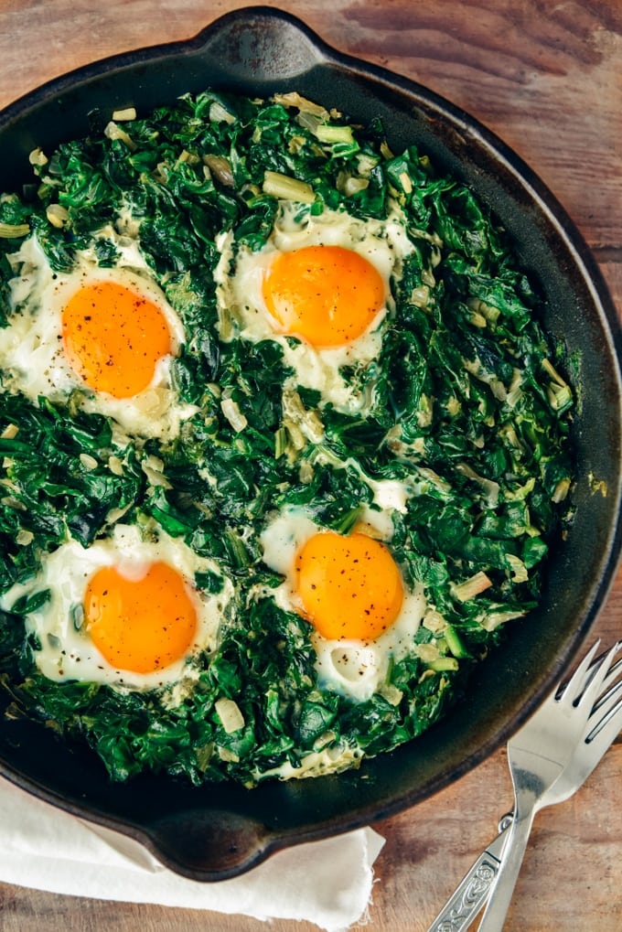 Fried eggs with spinach in a cast iron skillet