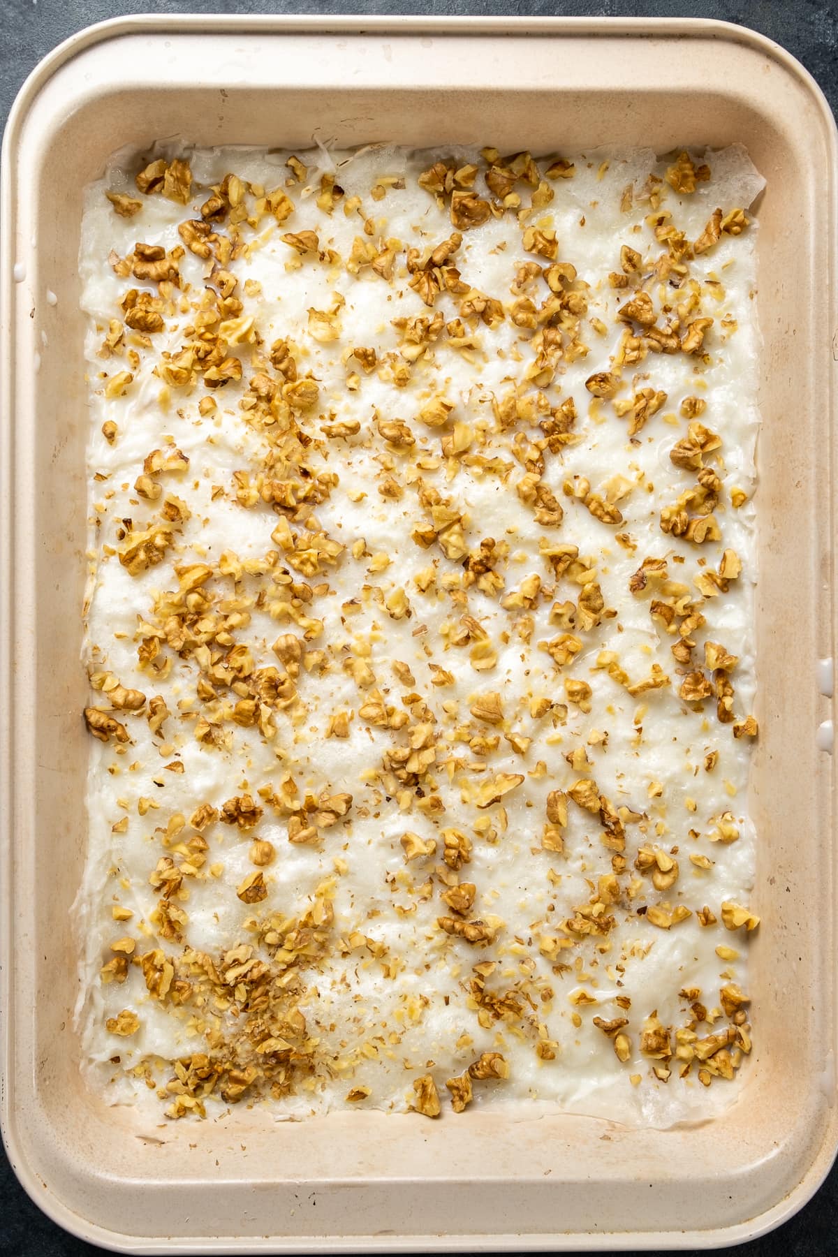 Gullac sheets wetted with milk and topped with walnuts