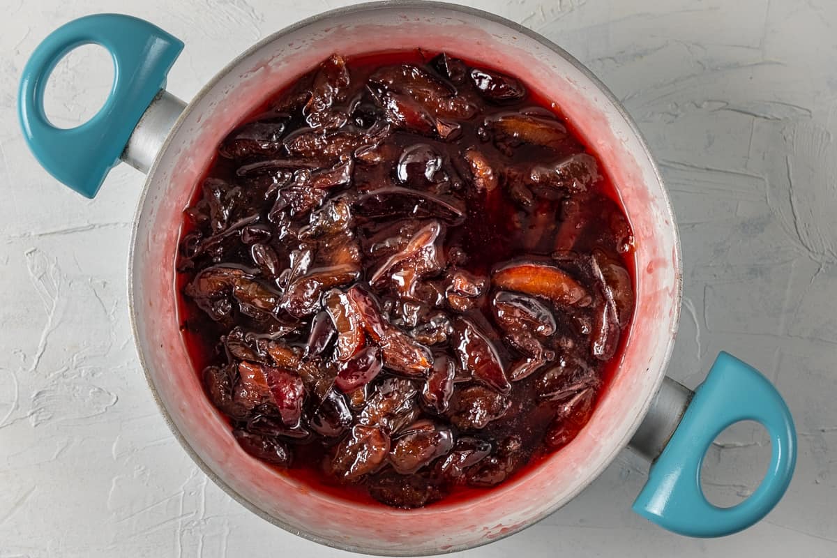 Damson plum jam with its beautiful red color in a pan.