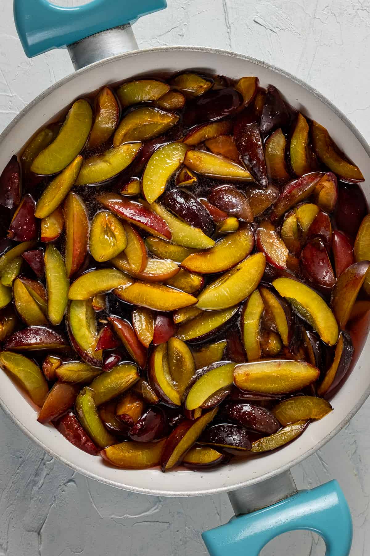 Sliced plums after waiting covered with sugar overnight.