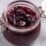 Small batch plum jam without pectin photographed in a glass jar.