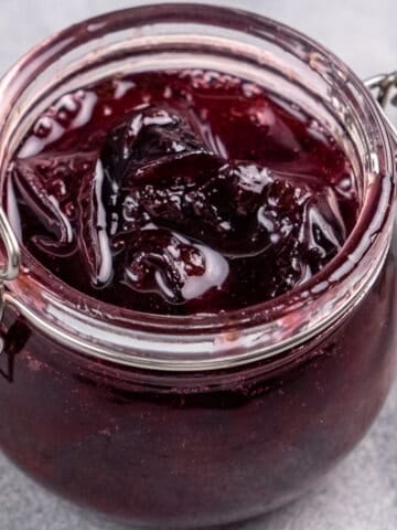 Small batch plum jam without pectin photographed in a glass jar.
