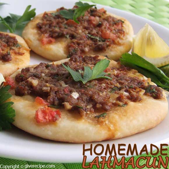 Mini lahmacun served with lemon wedges and parsley on a white plate.