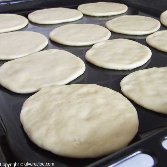 Mini lahmacun dough discs on a baking sheet.
