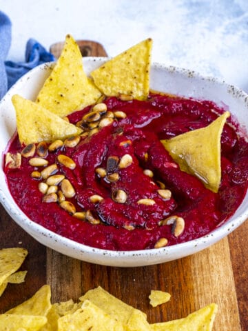 Beetroot dip garnished with toasted pine nuts and chips.