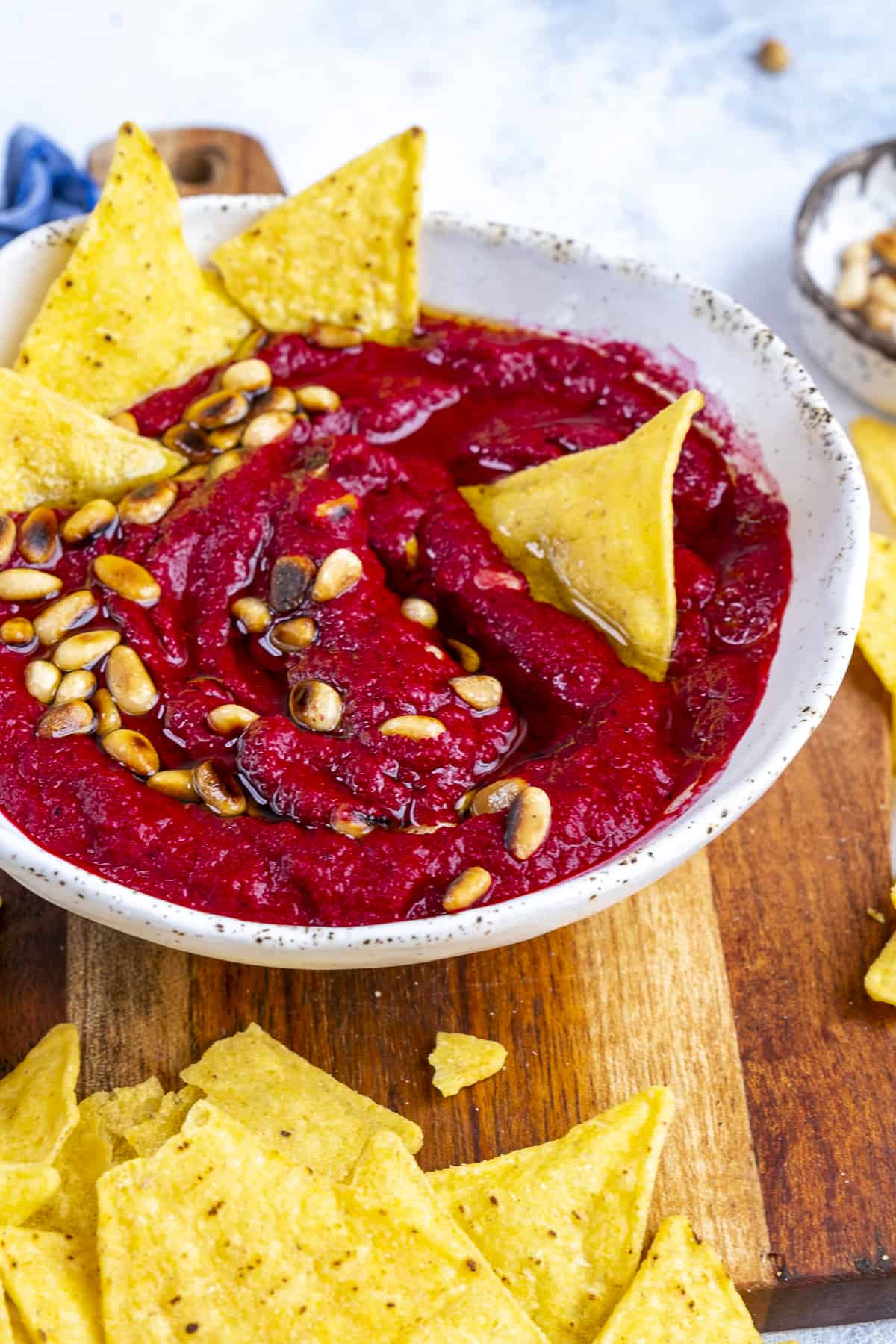 Beetroot dip in a white bowl served with chips.