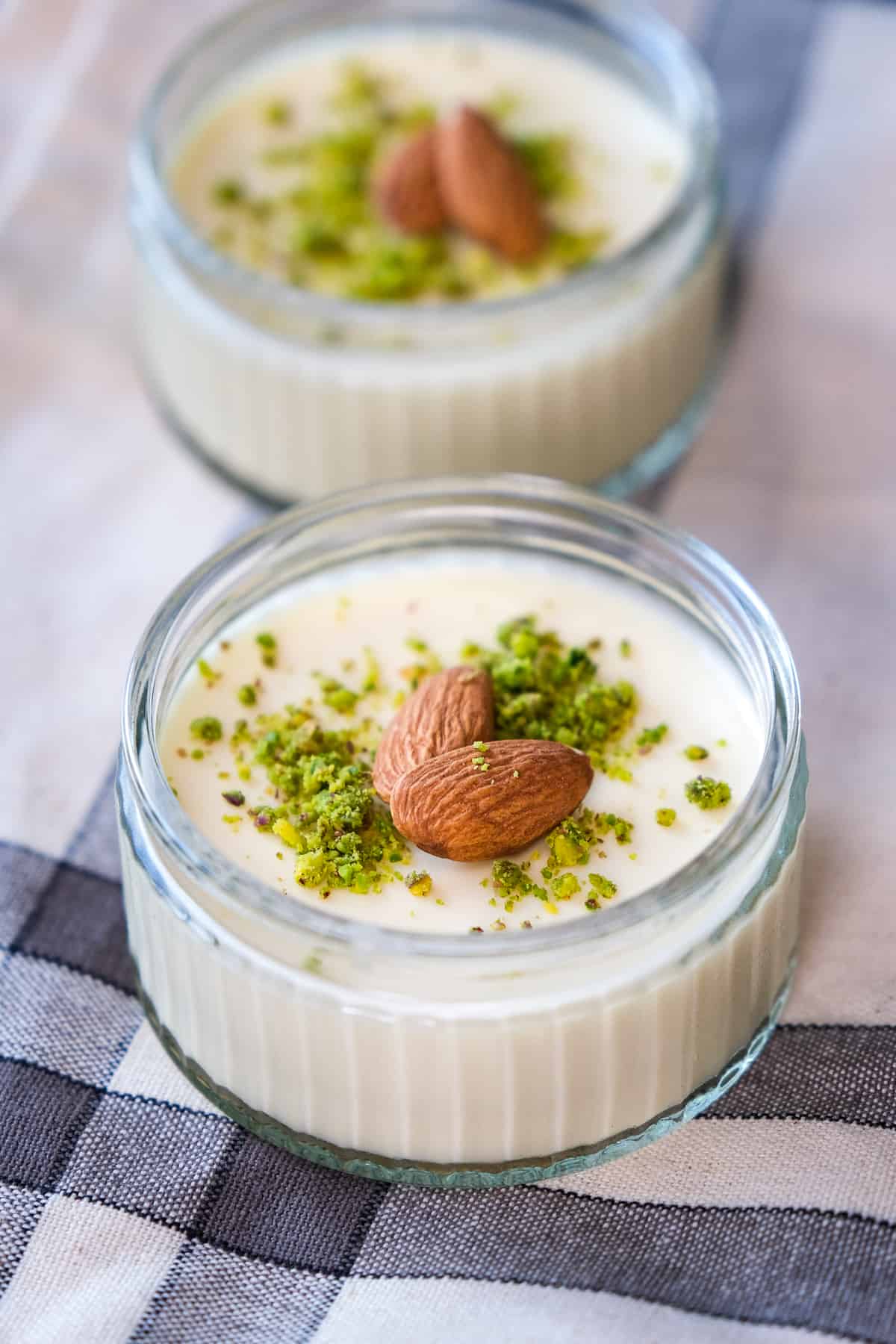 Keskul dessert topped with ground pistachios and whole almonds.