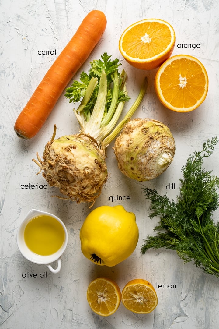 Celeriacs, carrot, orange, quince, lemon and fresh dill on a light background.