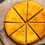 Turkish hot water cornbread in a round shape and sliced on a wooden board.