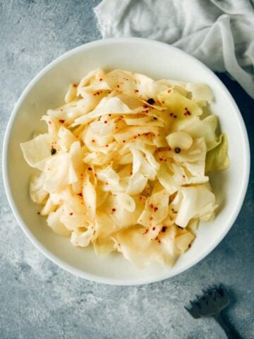 Quick pickled cabbage with hot chili flakes on a white plate
