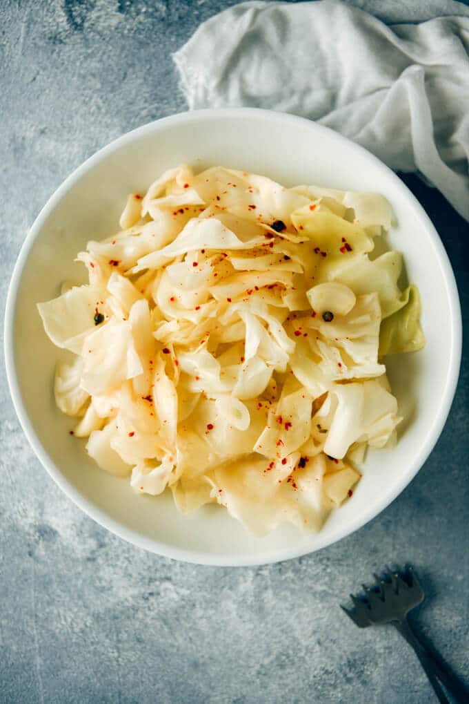 Quick pickled cabbage with hot chili flakes on a white plate