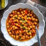 Turkish chickpea stew (Nohut Yemeği) served in a white bowl, garnished with parsley, with text overlay reading “Nohut Yemegi – Turkish Chickpea Stew.”