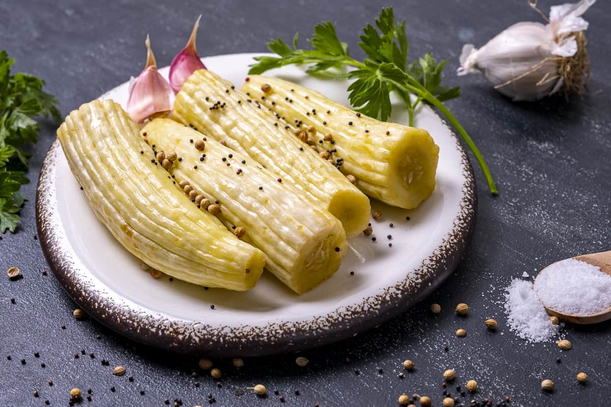 Pickled Armenian cucumbers on a white plate.