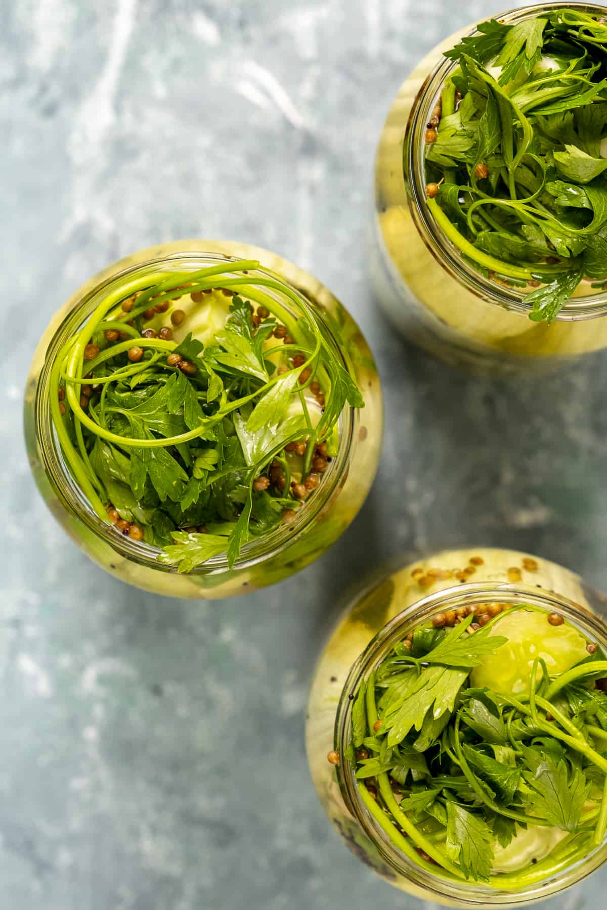 Armenian cucumbers are topped with parsley in tjhee jars.