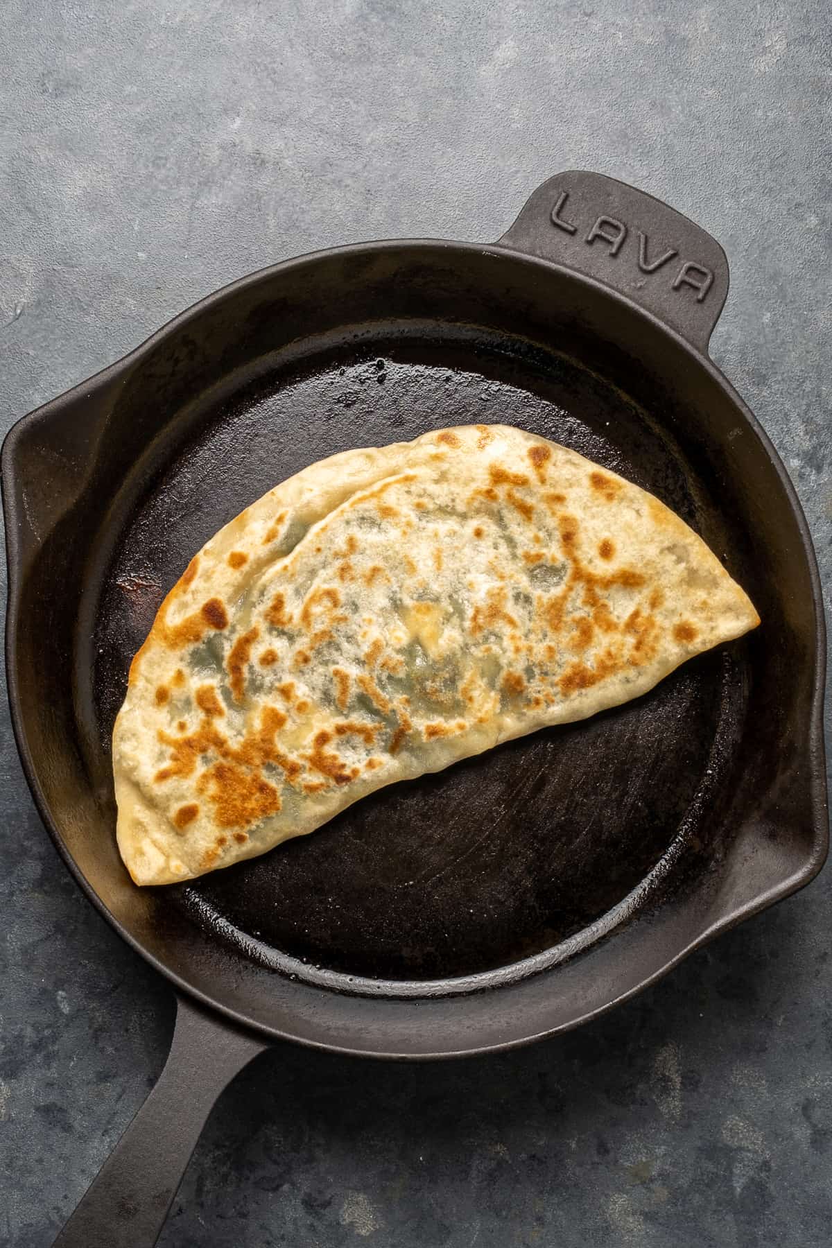 Gozleme cooking in a cast iron skillet