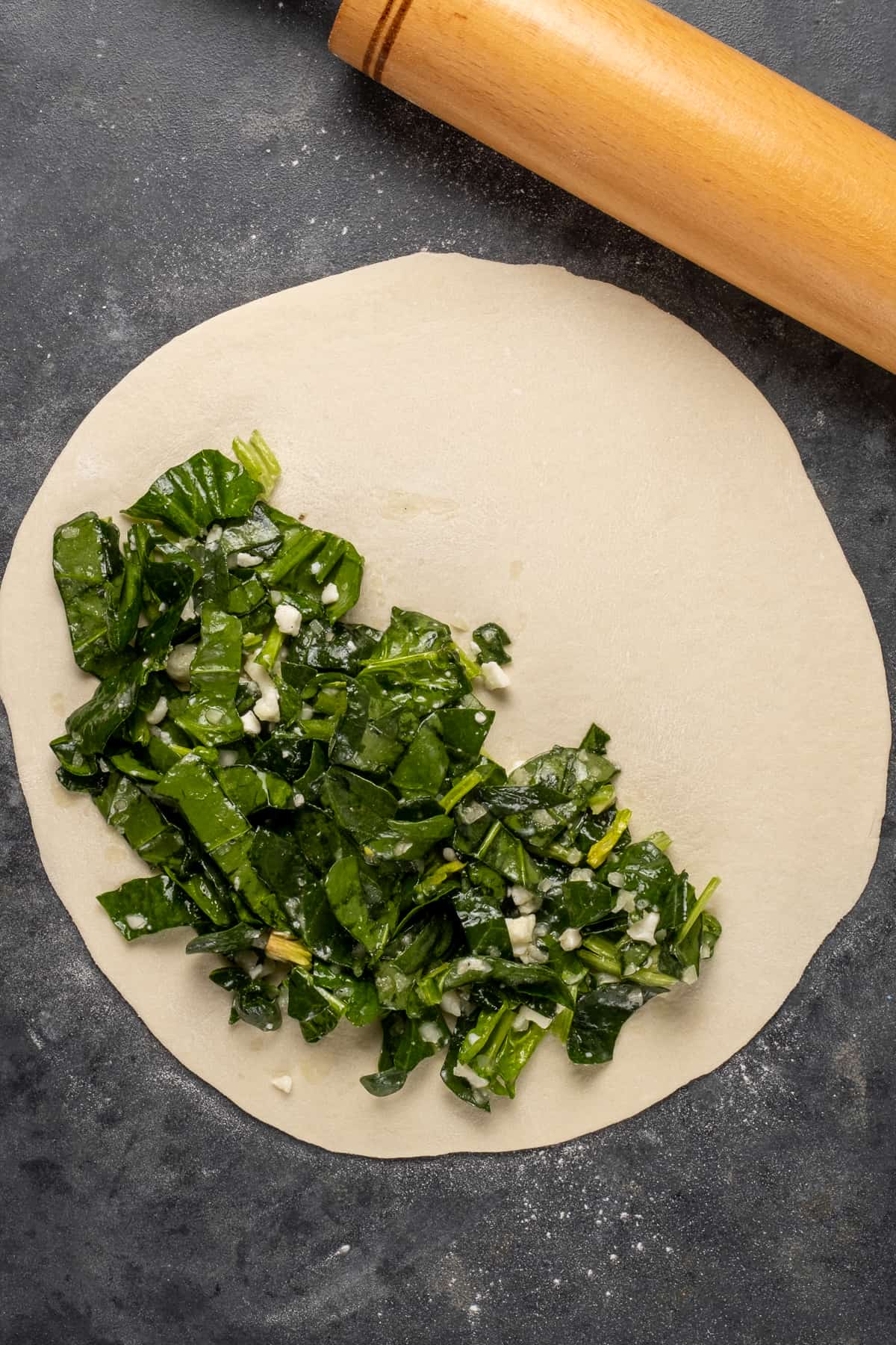 One half of the dough filled with spinach and cheese filling