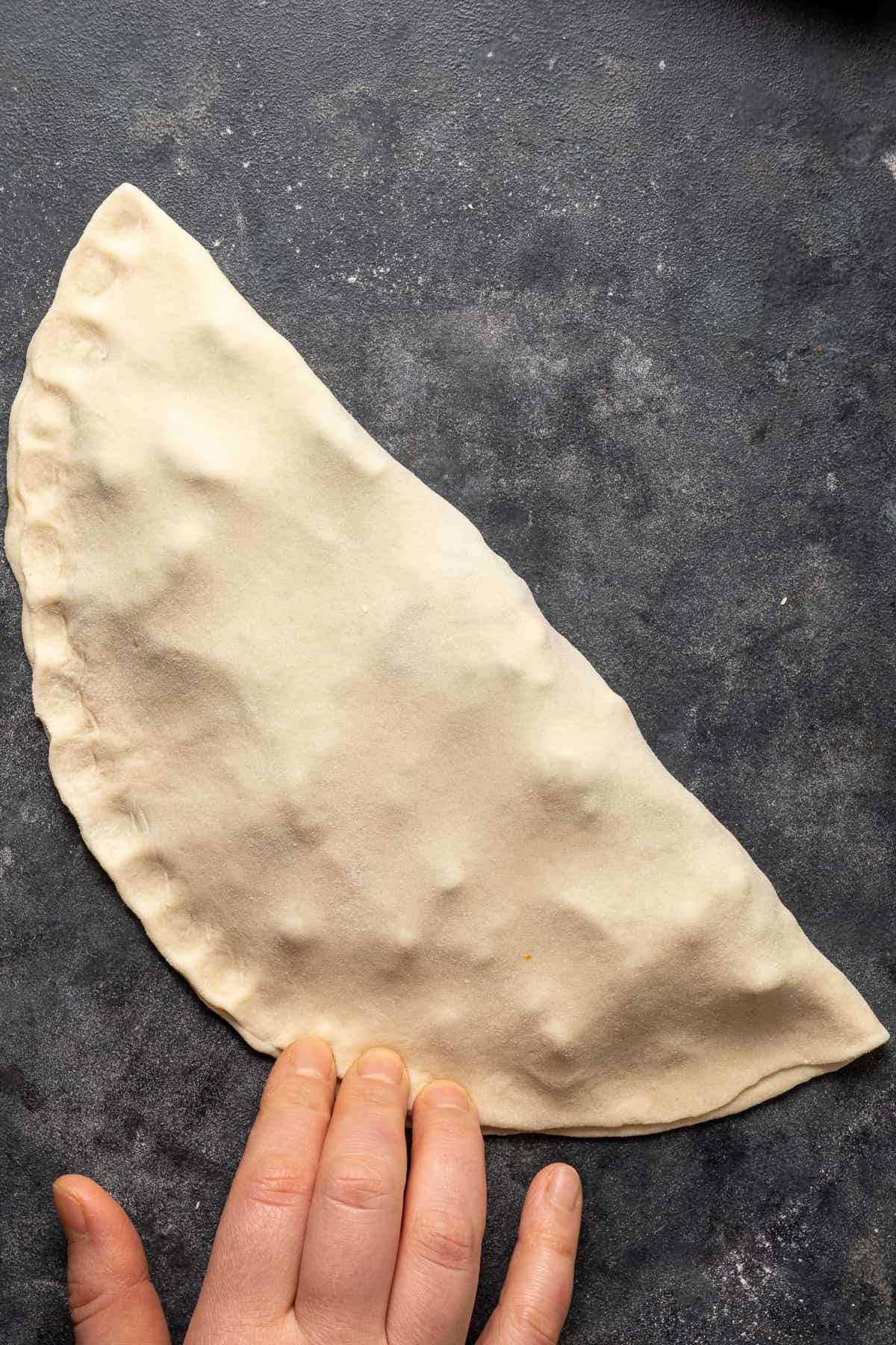 Sealing the edges of the filled dough to shape the gözleme