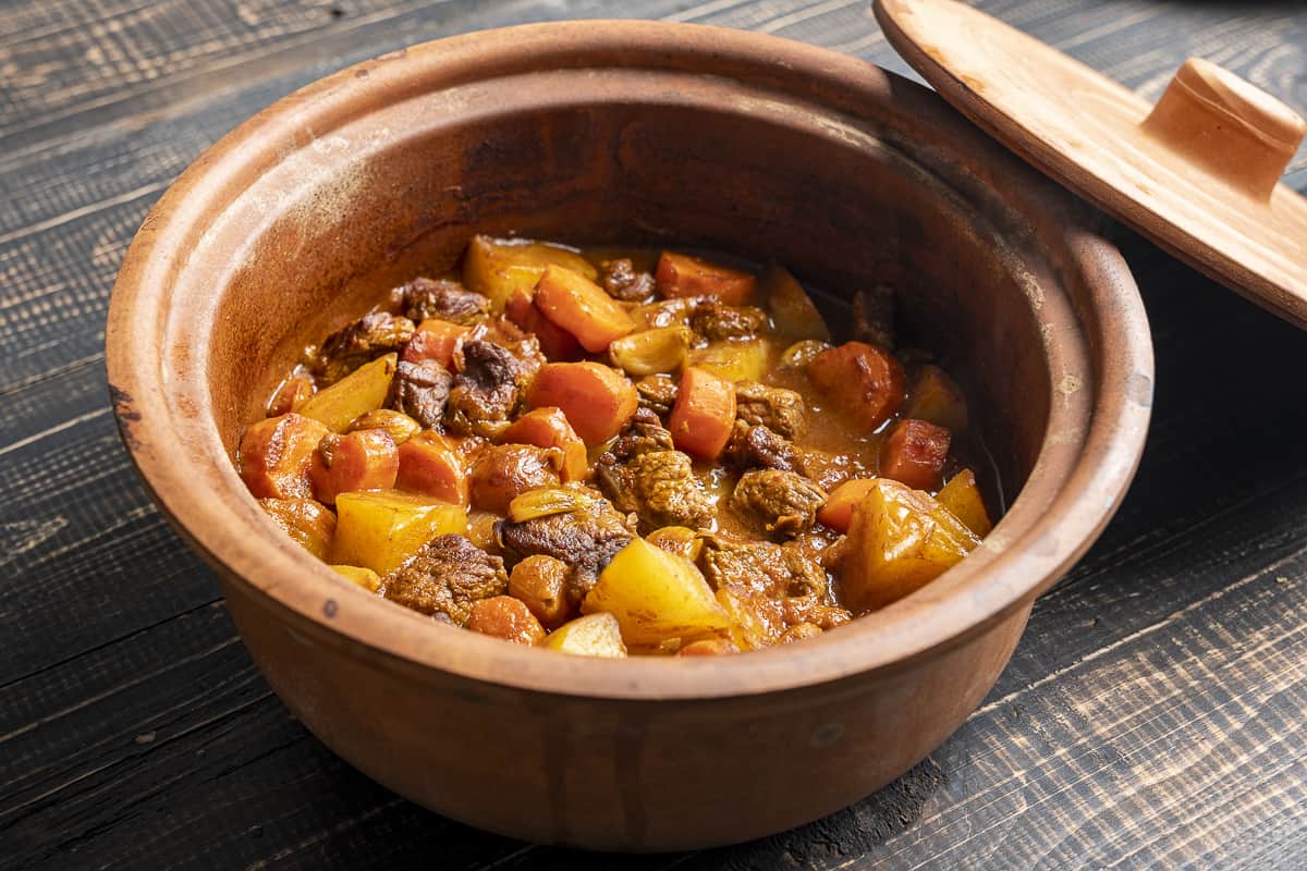 Beef stew with vegetables in a earthenware pot.