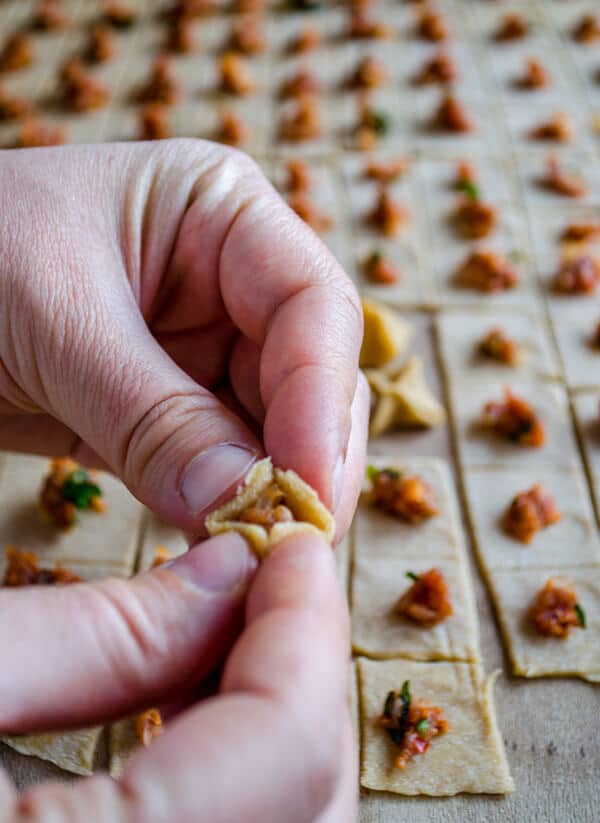 Hands showing how to close up manti dough.