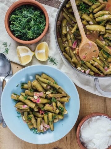 Fresh Fava Beans are braised in olive oil with tomatoes and onions and served at room temperature with lemon and yogurt. This is my favorite meatless dinner in spring.