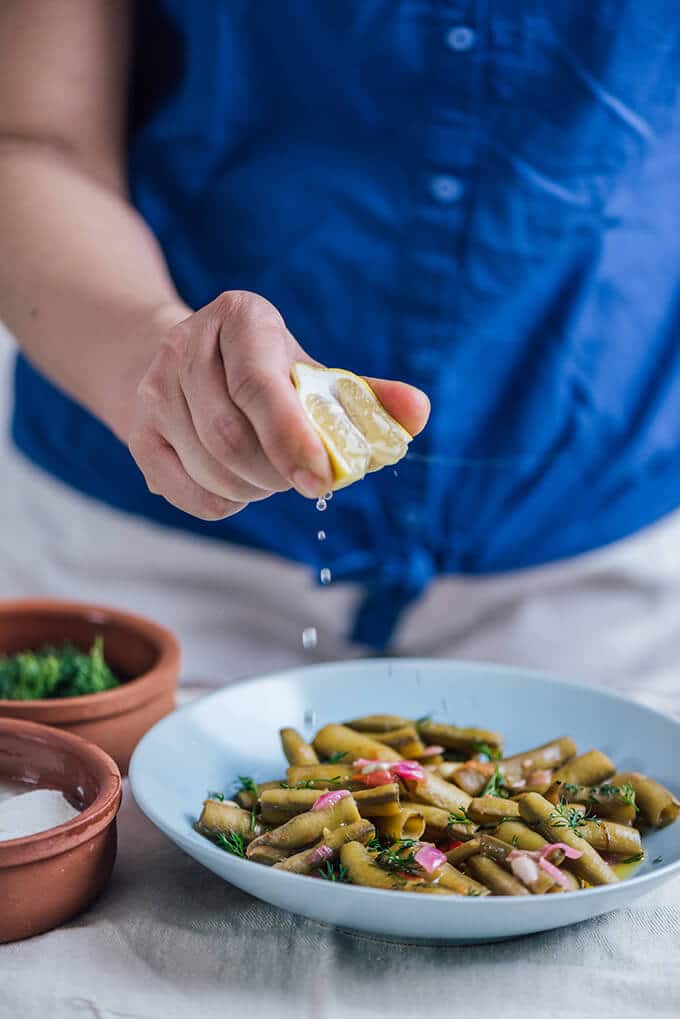 Fresh Fava Beans are braised in olive oil with tomatoes and onions and served at room temperature with lemon and yogurt. This is my favorite meatless dinner in spring.