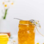 Homemade lemon jam in a jar accompanied by flowers