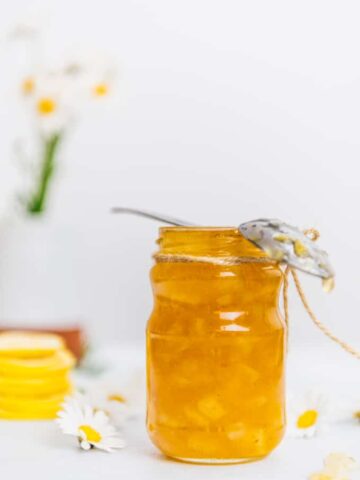 Homemade lemon jam in a jar accompanied by flowers