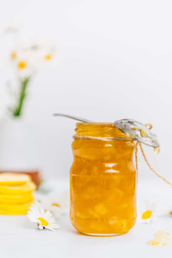 Homemade lemon jam in a jar accompanied by flowers