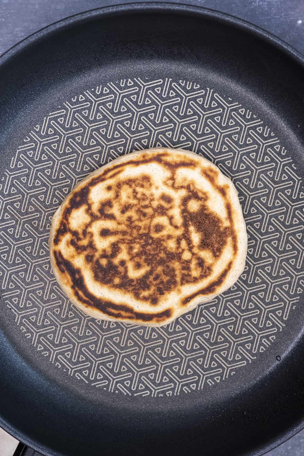 A pancake with a nice golden surface in a non-stick pan.