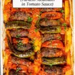 Meatballs and potatoes baked in tomato sauce in a white baking pan.