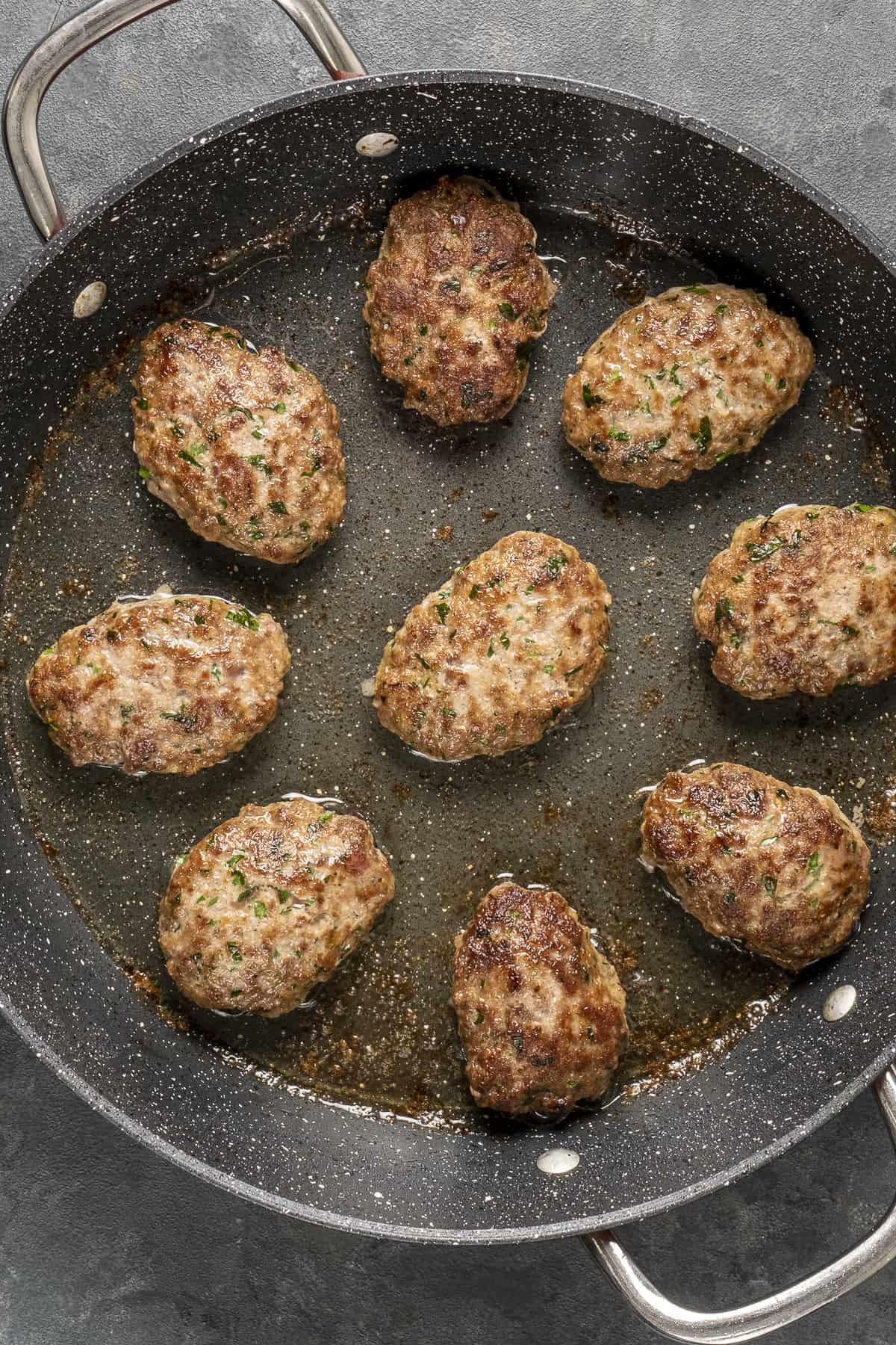 Meatballs frying in a pan.