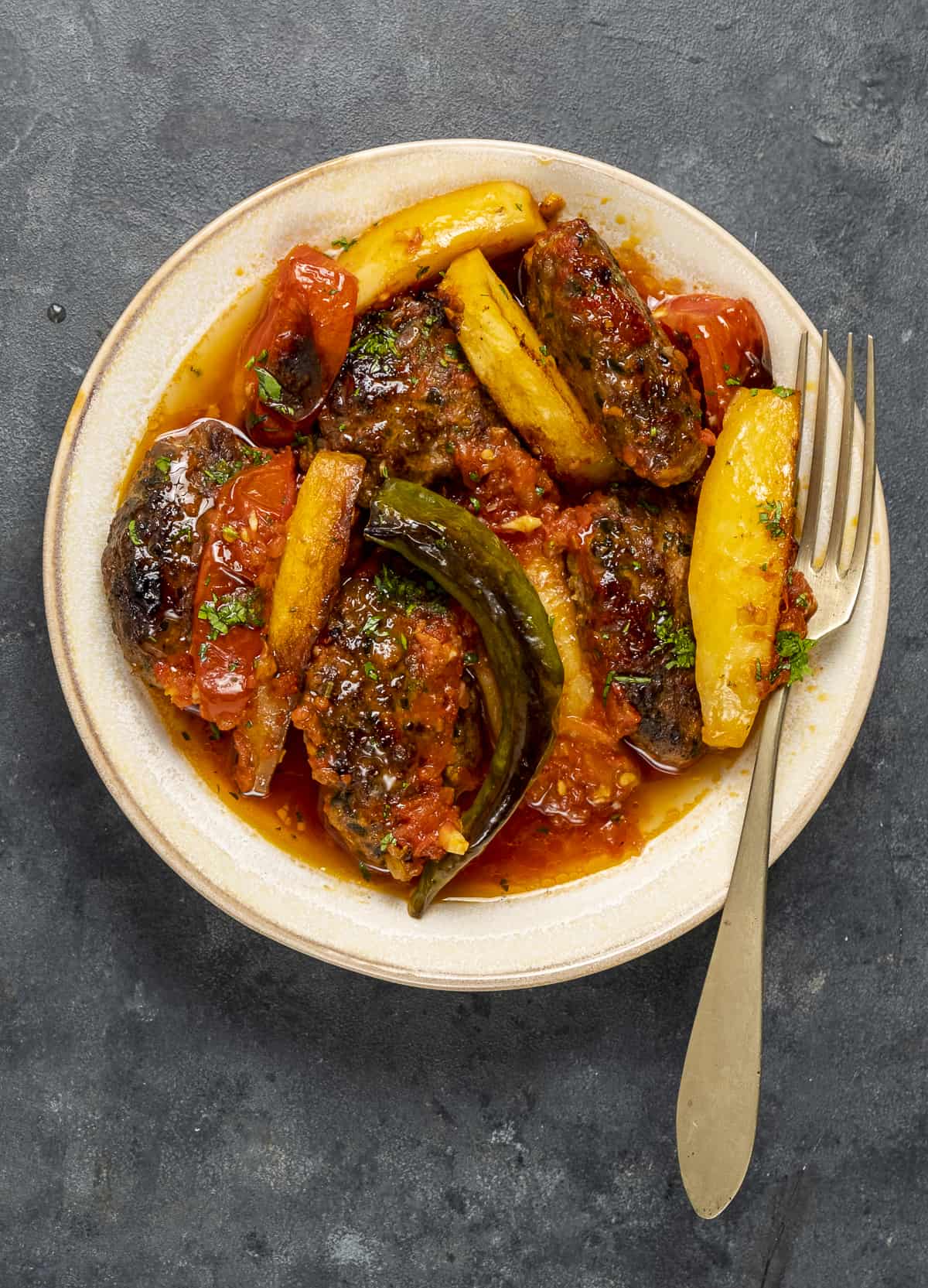 Izmir kofte with tomato sauce in a white bowl.