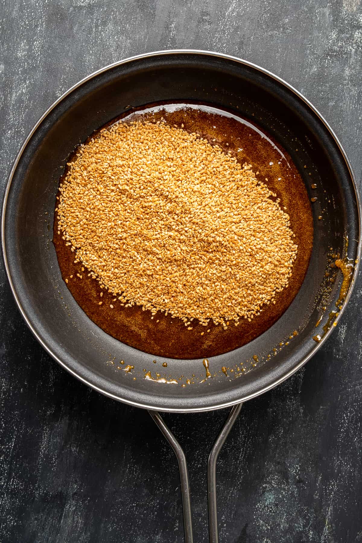 Toasted sesame seeds and melted sugar in a non stick pan.