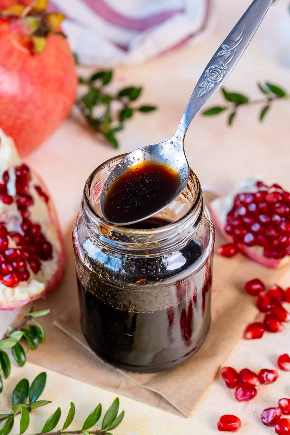 Pomegranate molasses in a jar and a spoon in it.