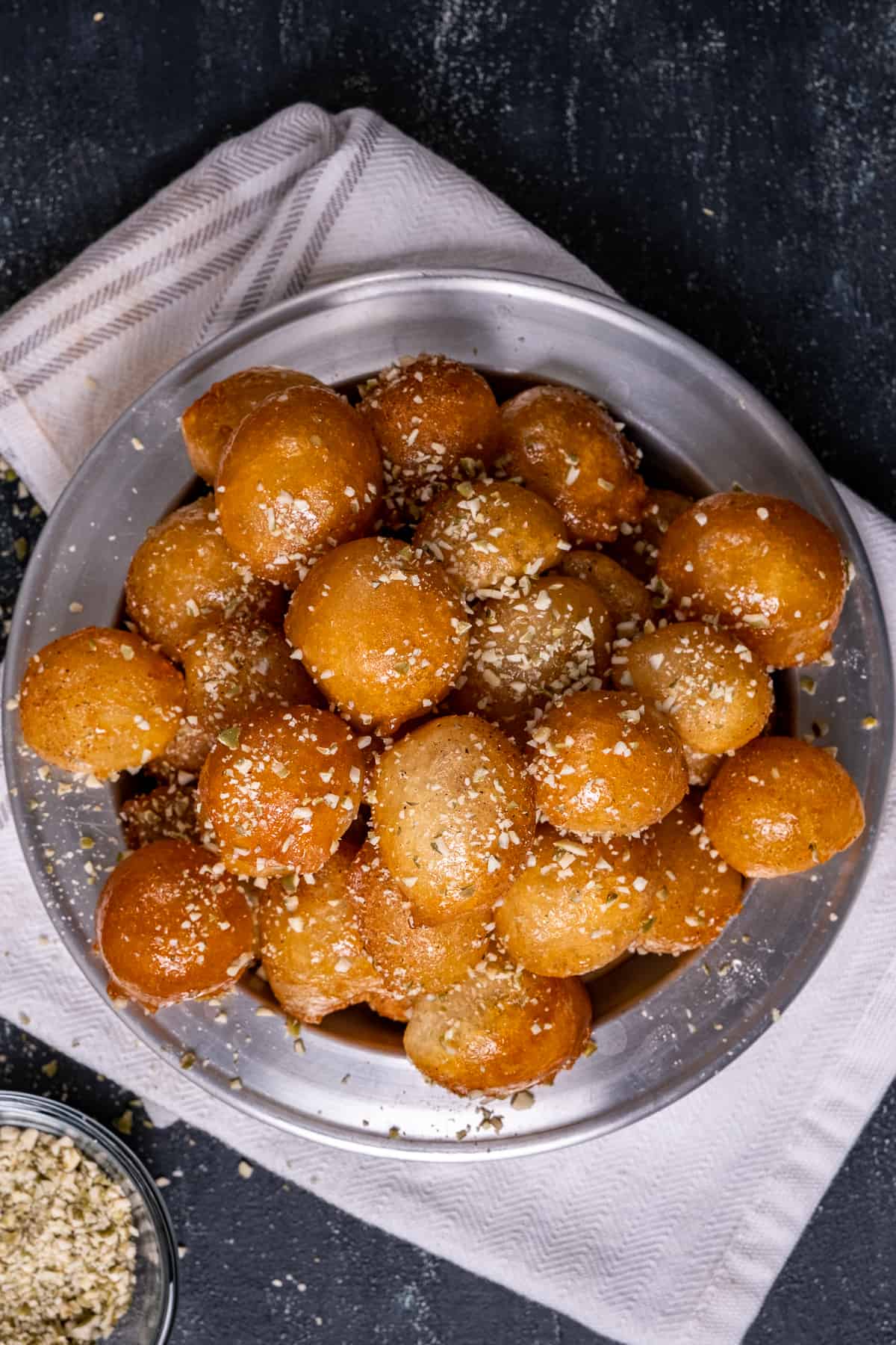 Turkish sweet fried dough balls sprinkled with ground walnuts. on a grey plate