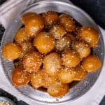 Turkish sweet fried dough balls sprinkled with ground walnuts. on a grey plate