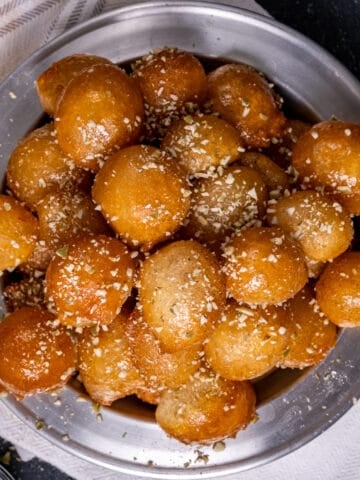 Turkish sweet fried dough balls sprinkled with ground walnuts. on a grey plate