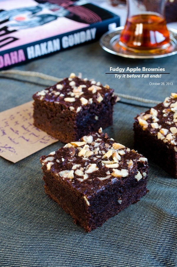 Apple and chocolate brownies photographed with a glass of tea and book behind