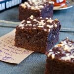 Chocolate apple brownies on a piece of paper with a recipe note