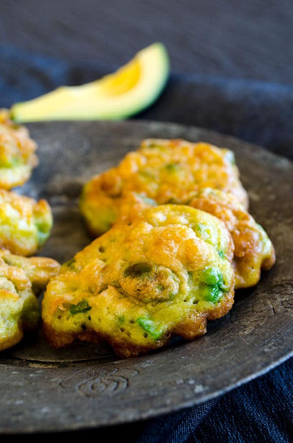 Avocado Corn Fritters served with yogurt dip make a wonderful appetizer for summer get-togethers. Packed with avocado, fresh corn and feta, these restaurant- style fritters are so addictive. They make a great after-school snack too! #cornfritters #avocadofritters #glutenfreefritters #afterschoolsnack Avocado corn fritters on a copper plate