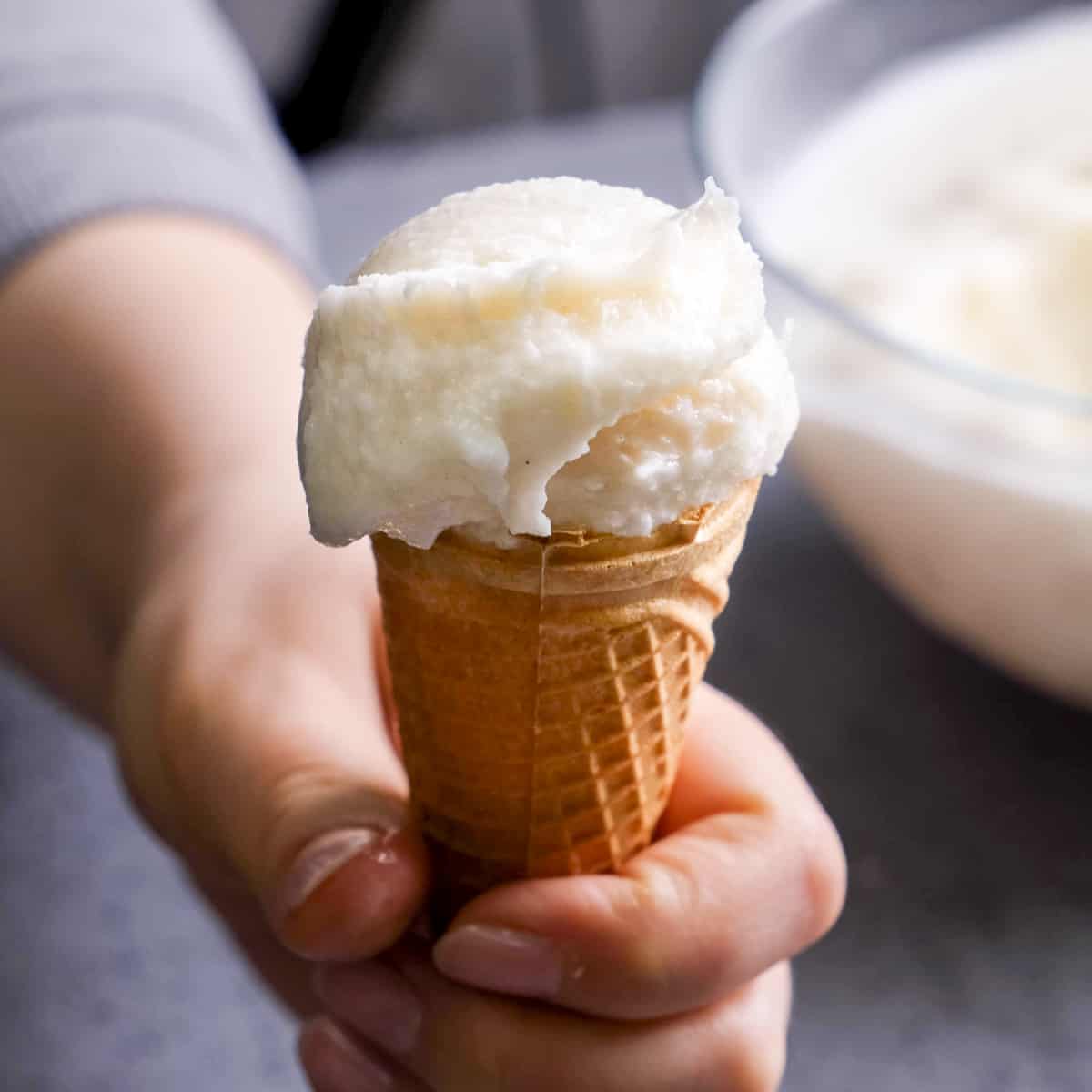 A woman hand holding ice cream on the cone.