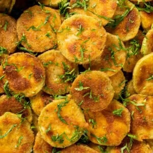 Golden fried zucchini chips garnished with parsley.