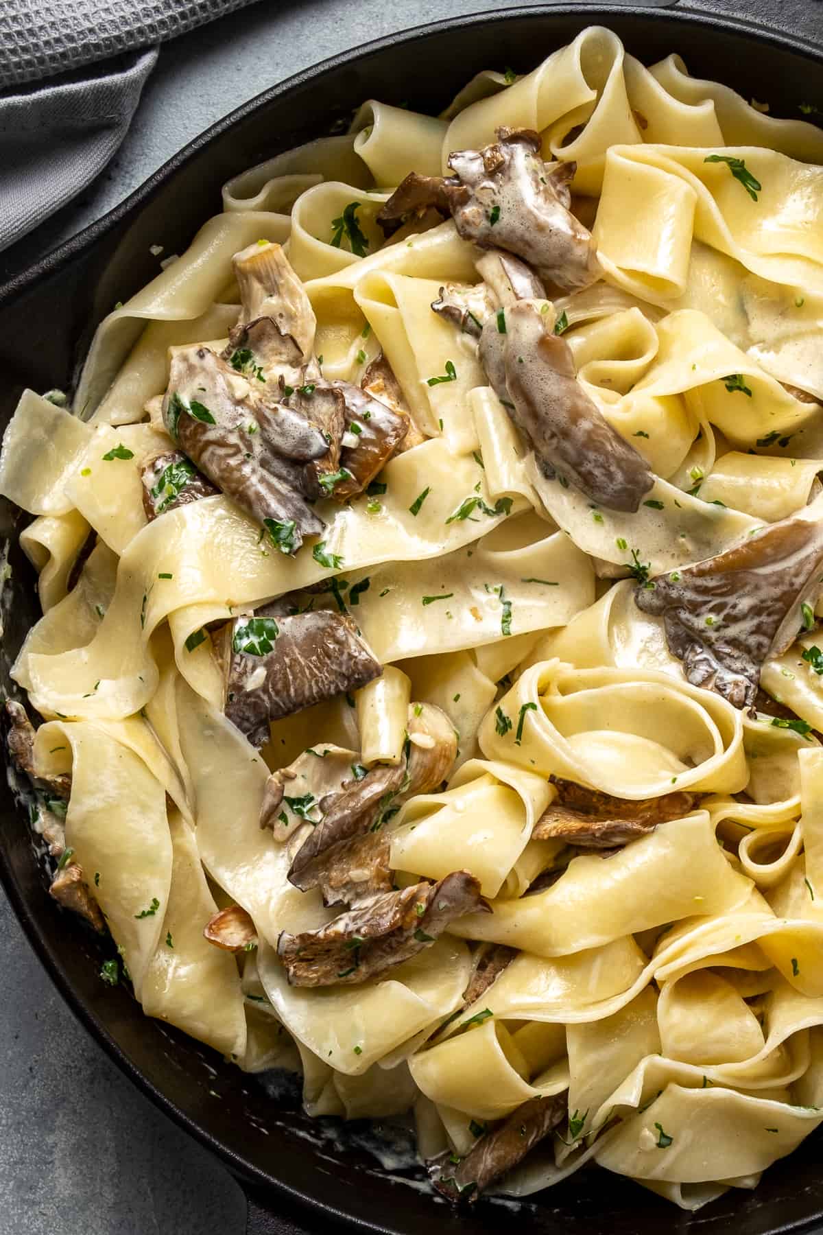 Pasta with creamy oyster mushroom sauce in a cast iron pan.