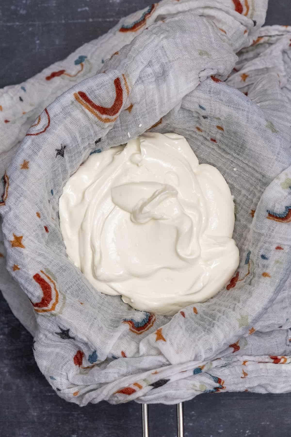 Regular yogurt in a baby muslin lined strainer.