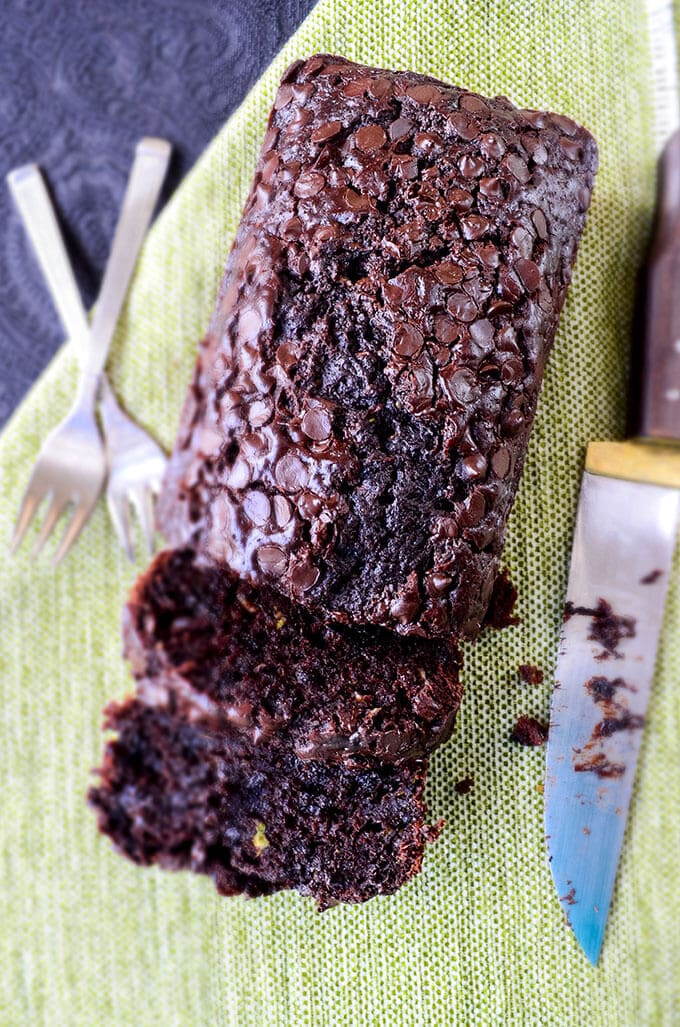 Super moist double chocolate zucchini bread with a knife and forks on the side
